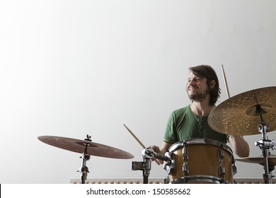 Smiling young man playing drum set