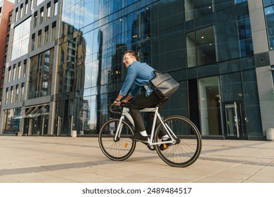 A smiling young man riding a bicycle past a modern glass office building, showcasing a vibrant and active urban lifestyle.

 - Powered by Shutterstock