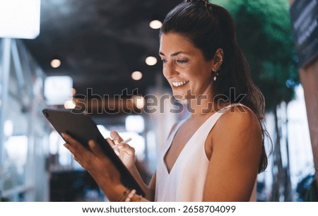 Smiling young man using digital tablet with stylus, fully immersed in creative freelance work. Concept of mobile productivity, remote design, and freedom of digital lifestyle.