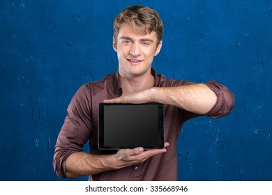 Smiling young man using tablet computer