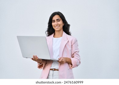 Smiling young middle eastern Israel businesswoman using laptop pc online application for work isolated on white background. Indian or arabic woman in business suit holding computer, looking at camera