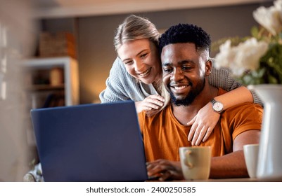 Smiling young mixed couple using a laptop while working on their home finances. - Powered by Shutterstock