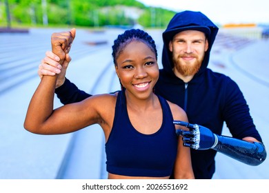 smiling young mixed race couple in sportswear warming up outdoors sity background early morning
