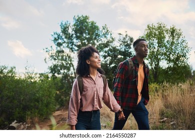 Smiling young multiethnic couple hiking together in some hills - Powered by Shutterstock