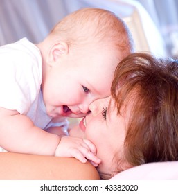 Smiling Young Mum And Baby In A Home Interior