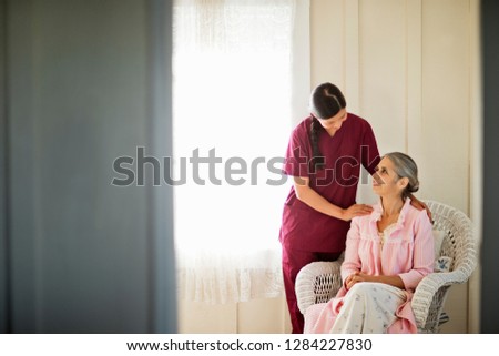 Similar – Image, Stock Photo Caregiver helping elderly female patient to get out of bed