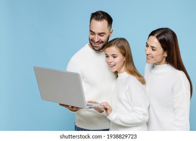 Smiling Young Parents Mom Dad With Child Kid Daughter Teen Girl In White Sweaters Working On Laptop Pc Computer Isolated On Blue Background Studio Portrait. Family Day Parenthood Childhood Concept