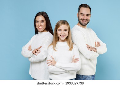 Smiling Young Parents Mom Dad With Child Kid Daughter Teen Girl In White Sweaters Holding Hands Crossed Isolated On Blue Color Background Studio Portrait. Family Day Parenthood Childhood Concept