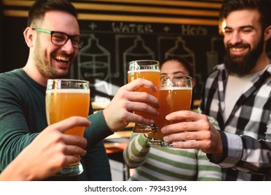 Smiling Young People Drinking Craft Beer In Pub