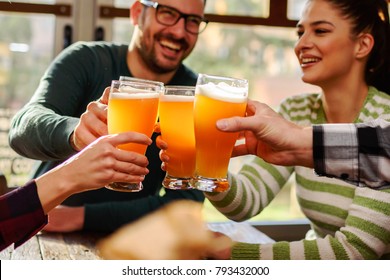 Smiling Young People Drinking Craft Beer In Pub