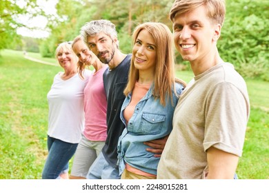 Smiling young people stand side by side in the park for friendship and togetherness - Shutterstock ID 2248015281