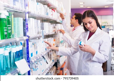 Smiling Young Pharmacist And Pharmacy Technician Posing In Drugstore