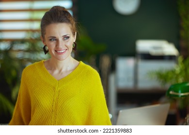 Smiling Young Small Business Owner Woman In Yellow Sweater Standing In The Modern Green Office.