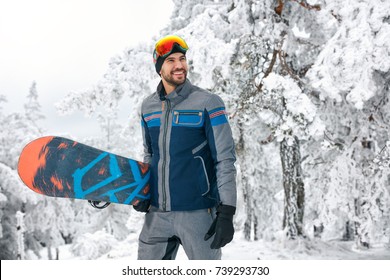 Smiling Young Snowboarder Holding Board For Snowboarding