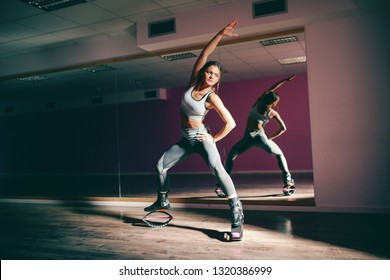 Smiling young sporty Caucasian brunette doing exercises with kangoo jumps footwear.
