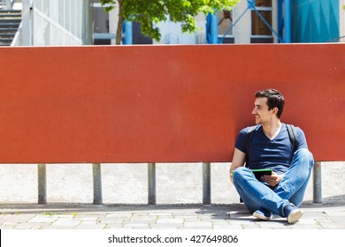 Smiling Young  Student Man Taping On Tablet  Using Tablet In Campus University.Young Smiling Student Outdoors With Tablet.Life Style.City