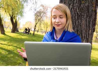 Smiling Young Ukrainian Woman Talking To Camera On Laptop In Park. Video Conference
