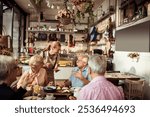 Smiling young waitress taking order from diverse senior people at a bistro