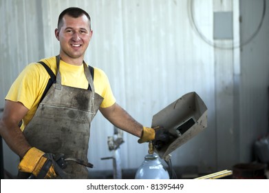 Smiling young welder at work - Shutterstock ID 81395449