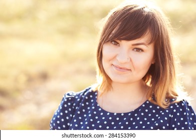 Smiling Young Woman 25-27 Year Old Wearing Stylish Blue Dress With White Polka Dots Outdoors. Looking At Camera. Ombre Hair. 