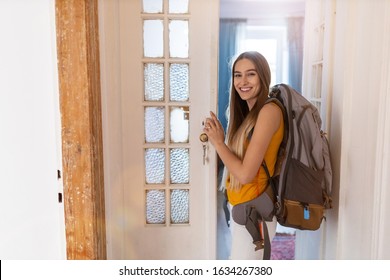 Smiling young woman with backpack at youth hostel 
