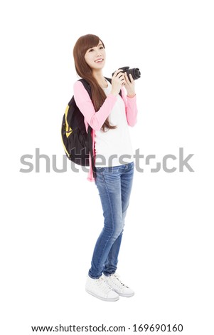 smiling young woman backpacker holding a camera 