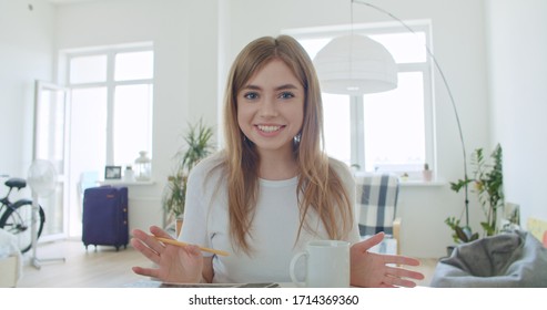 Smiling young woman blogger vlogger influencer working at home. Girl speaking looking at camera talking making videochat or conference call, Female record blog vlog