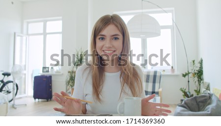Smiling young woman blogger vlogger influencer working at home. Girl speaking looking at camera talking making videochat or conference call, Female record blog vlog