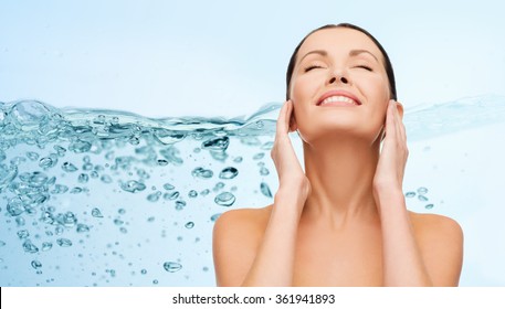 smiling young woman cleaning her face over water