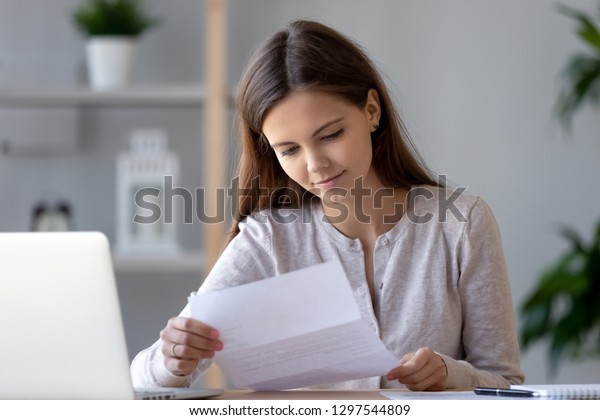 自宅でアドバイス書状を持つ書類を持つ笑顔の若い女性が 自宅で小切手用紙を読み 良い知らせに満足した銀行から通知書を受け取る女性客 の写真素材 今すぐ編集