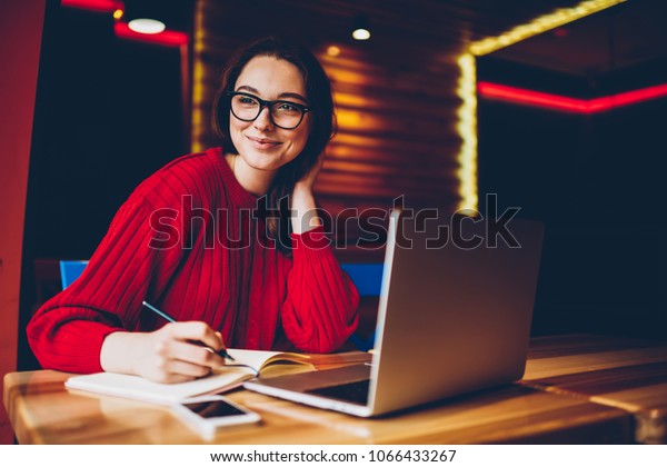 カフェのインテリアでフリーの仕事 を楽しみ メモ帳でアイデアをメモしている若い女性にほほ笑みを浮かべ ノートパソコンで学習するwi Fiに満足した気分で宿題をするポジティブな女性学生 の写真 素材 今すぐ編集 1066433267