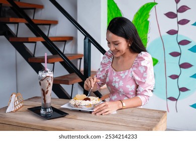 Smiling Young Woman Enjoying a Fresh Fruit Salad and Chocolate Milkshake - Powered by Shutterstock