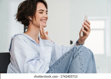 Smiling Young Woman Entrepreneur Having A Videocall While Sitting In The Office, Waving Hand