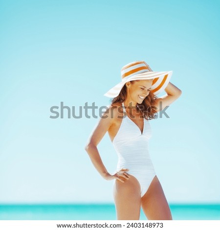 smiling young woman in hat on beach