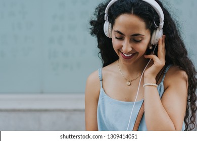 Smiling Young Woman Having Fun Listening To Music In City