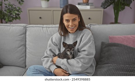 Smiling young woman holding a chihuahua in a cozy modern living room. - Powered by Shutterstock