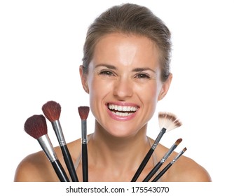 Smiling Young Woman Holding Makeup Brushes