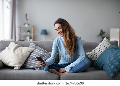 Junge Frau zu Hause mit modernem Smartphone lächeln. Online-Chat.