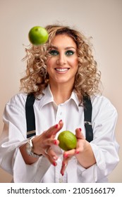 Smiling Young Woman Juggling With Three Green Apples