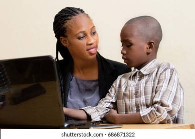Smiling young woman learns computer skills from child with kindness.