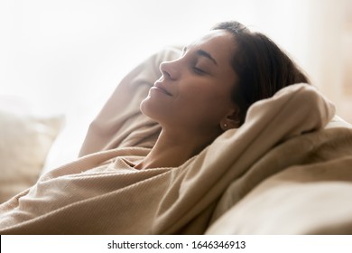 Smiling young woman lying on comfortable couch hands over head relaxing on sunny weekend at home, happy calm millennial girl rest on sofa in living room, breathe fresh air, stress free concept - Shutterstock ID 1646346913