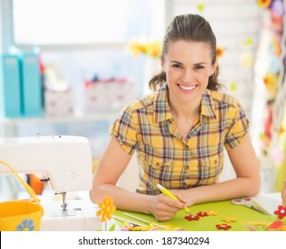 Smiling young woman making easter decoration