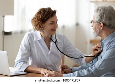 Smiling young woman nurse using stethoscope, checking mature patient heartbeat or lungs sound, breath, friendly physician gp consulting senior man at meeting in hospital, medical checkup - Powered by Shutterstock