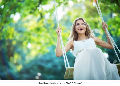 Smiling Young Woman On A Swing