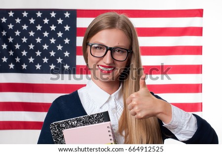 Smiling young woman on United States flag background. Student is learning English as a foreign language. American flag. 