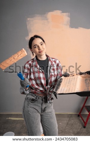 Smiling young woman painting wall of home. Renovation, repair and redecoration concept. [[stock_photo]] © 