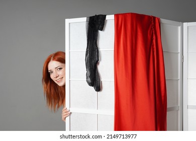 Smiling Young Woman Peeks From Behind Japanese Folding Screen While Undressing Or Changing Her Clothes