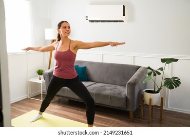 Smiling Young Woman Practicing Yoga And Enjoying The Cold Air Of The Air Conditioning