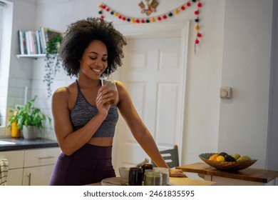 Smiling young woman preparing healthy drink at home - Powered by Shutterstock