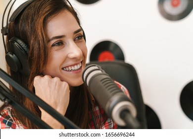 Smiling young woman radio host making podcast recording for online show